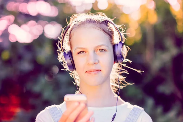 Ragazza carina ascoltare musica con le cuffie all'aperto — Foto Stock