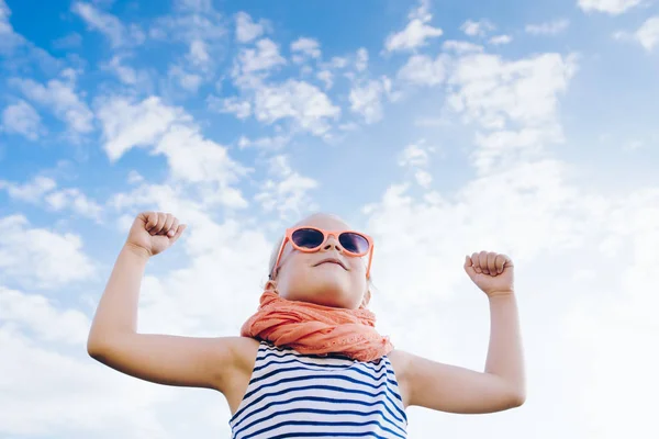 Happy beautiful child girl  with raised arms against sky — Stock Photo, Image