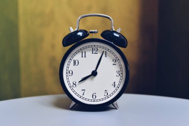 Retro vintage renk arka plan ile tabloda çalar saat