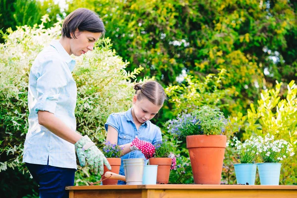 Madre e hija plantando flores en macetas en el jardín — Foto de Stock