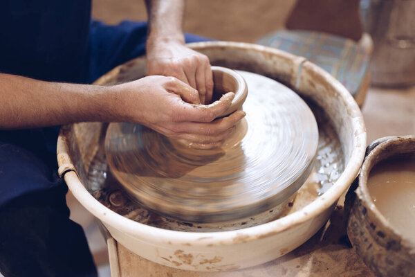 Potter making a clay vase on a potter's wheel