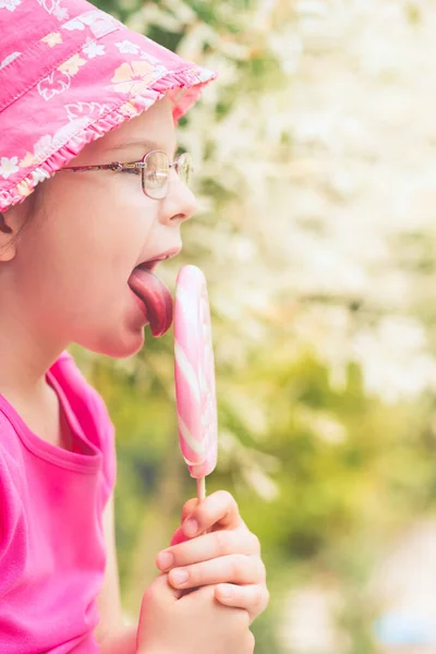 Pembe Şapkalı Küçük Kız Büyük Lolipop Yalıyor — Stok fotoğraf