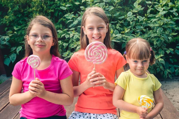 Три Забавные Маленькие Девочки Красочных Футболках Большими Леденцами Террасе Саду — стоковое фото