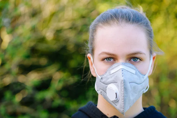 young girl with anti-virus anti-smog mask on her face. Wearing hygiene masks reduces the risk of getting COVID-19 disease caused by coronavirus; it also prevents smog allergies