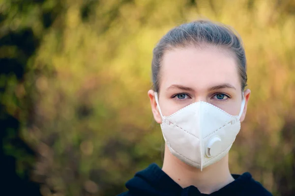 young girl with anti-virus anti-smog mask on her face. Wearing hygiene masks reduces the risk of getting COVID-19 disease caused by coronavirus; it also prevents smog allergies