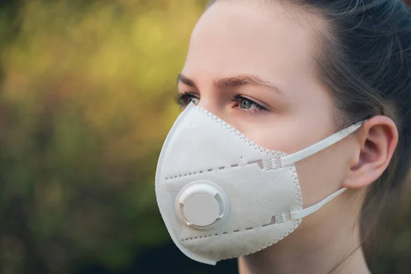 young girl with anti-virus anti-smog mask on her face. Wearing hygiene masks reduces the risk of getting COVID-19 disease caused by coronavirus; it also prevents smog allergies