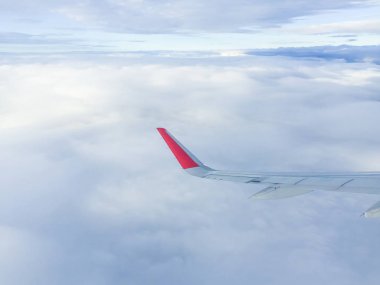 Gökyüzündeki bulutların üzerinde uçan uçağın kanatları