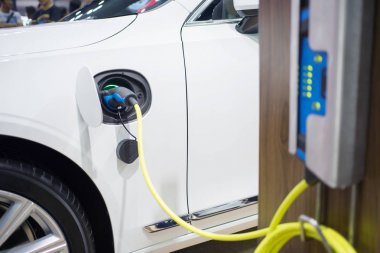 Elektrik kablosu prize takılı bir elektrikli arabayı şarj etmek...
