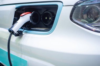 Elektrik kablosu prize takılı bir elektrikli arabayı şarj etmek...