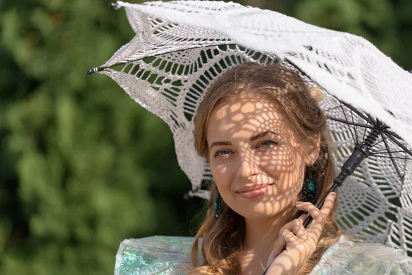 Vrouw onder een paraplu tegen de zon — Stockfoto