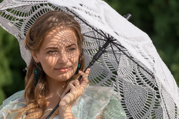 Vrouw onder een paraplu tegen de zon — Stockfoto