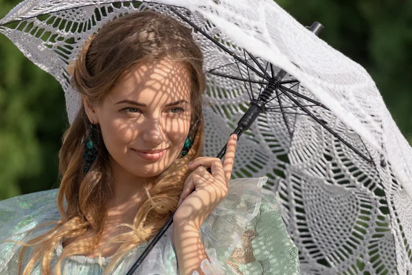 Vrouw onder een paraplu tegen de zon — Stockfoto