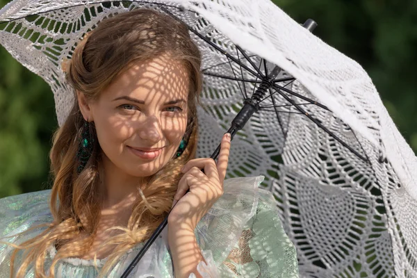 Vrouw onder een paraplu tegen de zon — Stockfoto