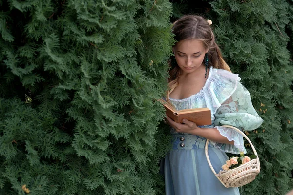 Meisje het lezen van een boek in een groene omheining — Stockfoto