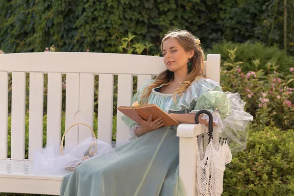 Meisje het lezen van een boek in de zomertuin — Stockfoto
