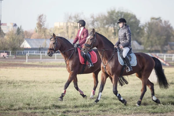 Gomel, Vitryssland - 16 oktober 2016: Två tjejer rider värma upp hästarna innan tävlingen — Stockfoto