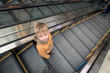 büyük bir mağazadan bir yürüyen merdiven üzerinde çocuk rides