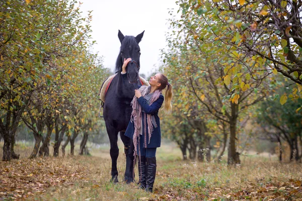 Krásná stylová holka v kovbojském klobouku s koněm, chůze v podzimním lese, stylu country — Stock fotografie