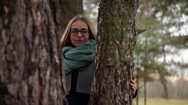 Kız bir çam koruyucu elbise sonbaharda oturuyor.