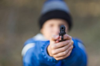 sokakta bir oyuncak tabanca ile sonbaharda oynayan çocuk