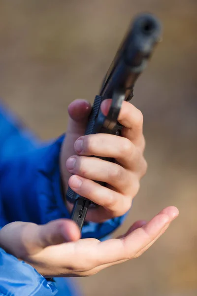 Boy playing with a toy gun on the street in autumn — Stock Photo, Image