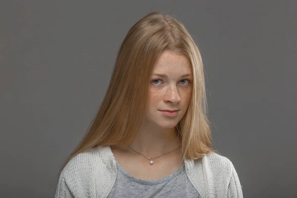 Roodharige meisje close-up op een grijze achtergrond — Stockfoto