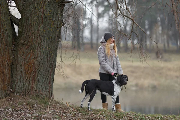 Menina com um cão para um passeio no outono — Fotografia de Stock