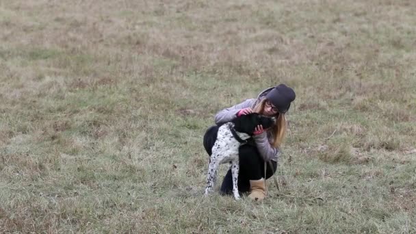 Дівчина з собакою для прогулянки восени — стокове відео