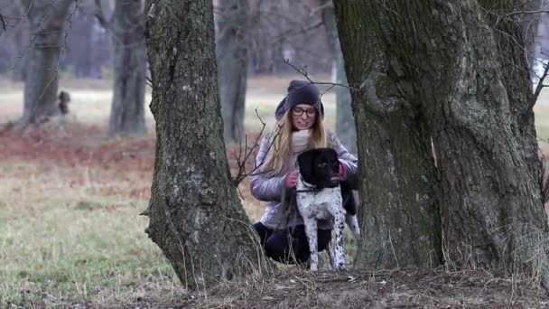 Tjej med en hund på en promenad i höst — Stockvideo