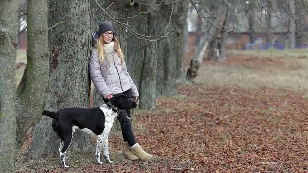 Meisje met een hond voor een wandeling in de herfst — Stockvideo