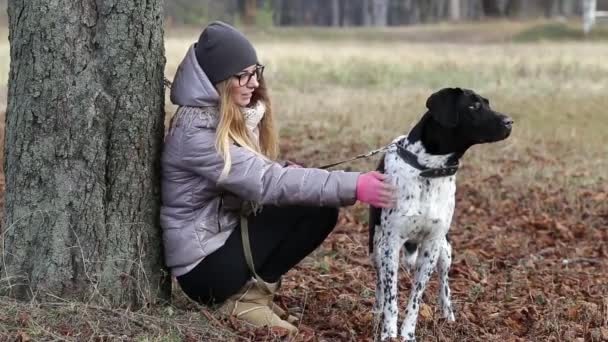 Дівчина з собакою для прогулянки восени — стокове відео