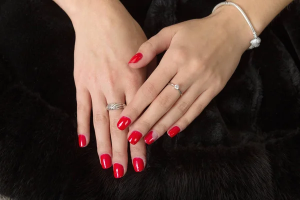 Mãos da mulher com unhas pintadas no fundo preto — Fotografia de Stock