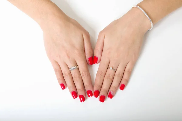 As mãos da mulher com unhas pintadas em um fundo branco — Fotografia de Stock