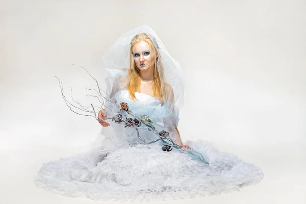 Blonde in een witte jurk met blauwe make-up. De sneeuwkoningin. — Stockfoto