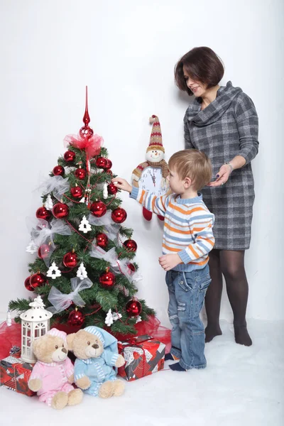 Madre con il suo giovane figlio su uno sfondo bianco in un albero di Natale — Foto Stock