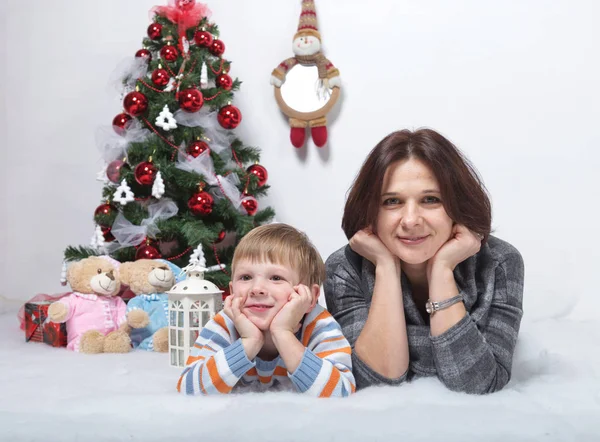 Madre con il suo giovane figlio su uno sfondo bianco in un albero di Natale — Foto Stock