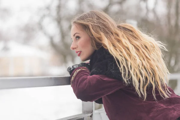Krásná dívka stojící na most pro pěší v zimě — Stock fotografie