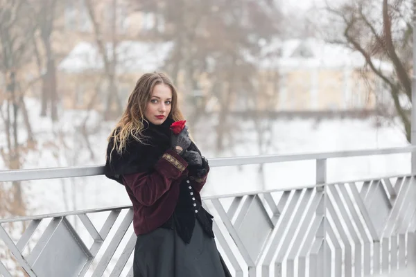 漂亮的女孩站在人行天桥上，在冬季 — 图库照片