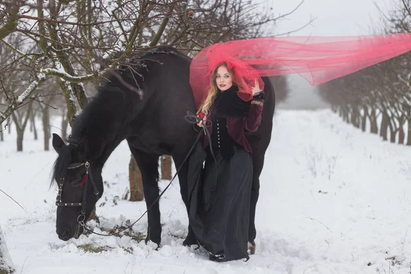 Chica en un velo rojo en la nieve en el invierno — Foto de Stock