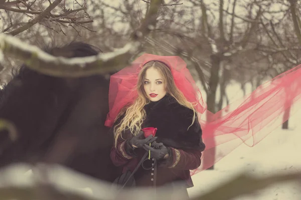 Chica en un velo rojo en la nieve en el invierno — Foto de Stock