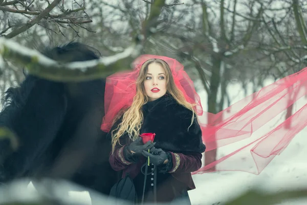 Chica en un velo rojo en la nieve en el invierno — Foto de Stock