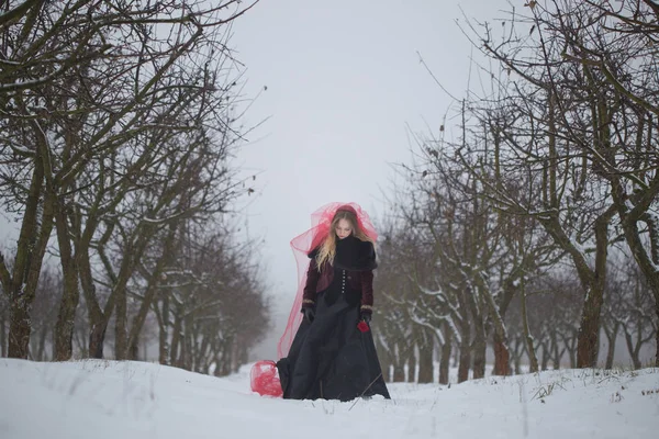Fata într-un văl roșu pe zăpadă în timpul iernii — Fotografie, imagine de stoc