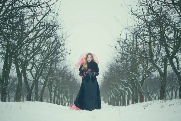 Chica en un velo rojo en la nieve en el invierno — Foto de Stock