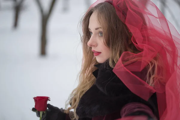 Chica en un velo rojo en la nieve en el invierno — Foto de Stock