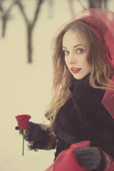 Chica en un velo rojo en la nieve en el invierno — Foto de Stock