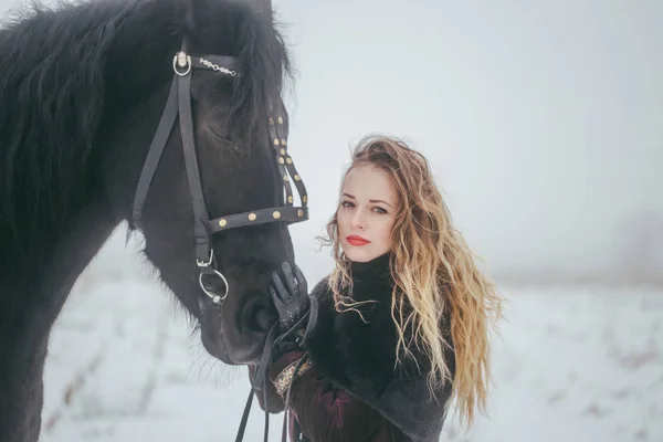 一个女孩与一匹马在冬天中的一个字段 — 图库照片