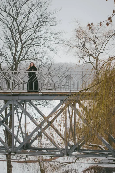 Fată frumoasă în picioare pe podul pietonal în timpul iernii — Fotografie, imagine de stoc