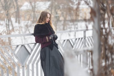 güzel kız kış aylarında yaya köprüsü üzerinde ayakta