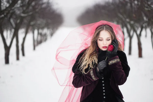 Mädchen im roten Schleier auf dem Schnee im Winter — Stockfoto