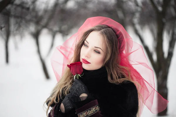 Chica en un velo rojo en la nieve en el invierno — Foto de Stock